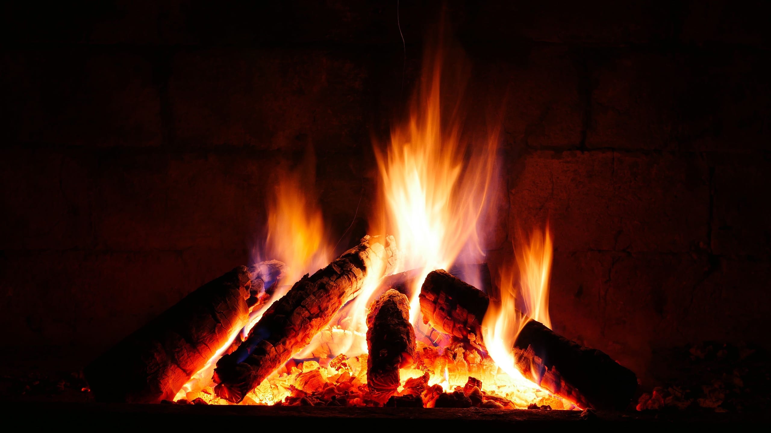 Glowing embers of a dying fire in a dark room